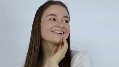 Close up of a stunning young female model posing after doing her face shin care makeup