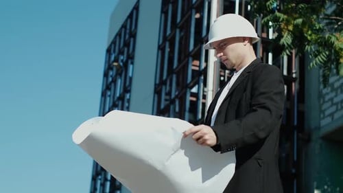 Engineer Reviews Construction Plans on a Building Site