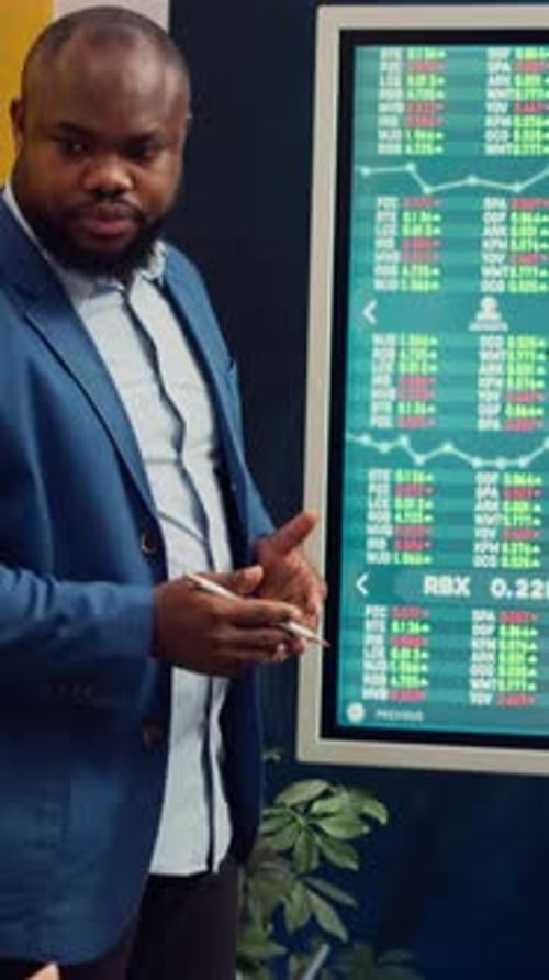 Team of Business Analysts Following Stock Trade Trends on Interactive Board