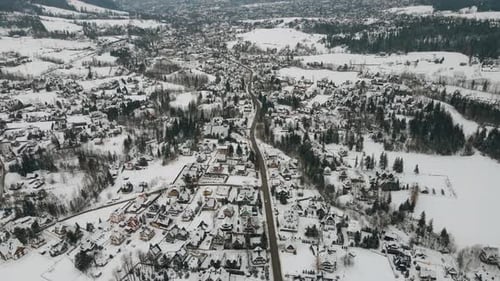 Aerial view of village in the mountains during winter. Mountain village buildings and houses on snow