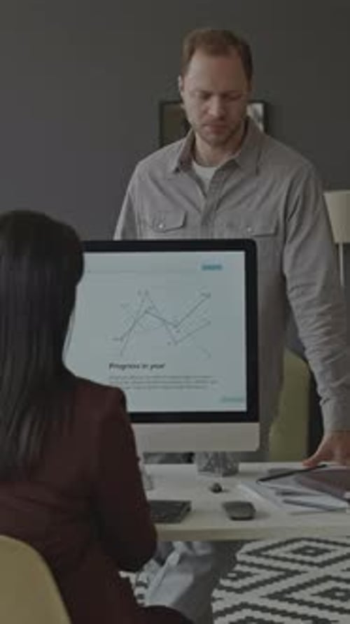 Businesswoman Discussing Financial Data with Employee at Workplace