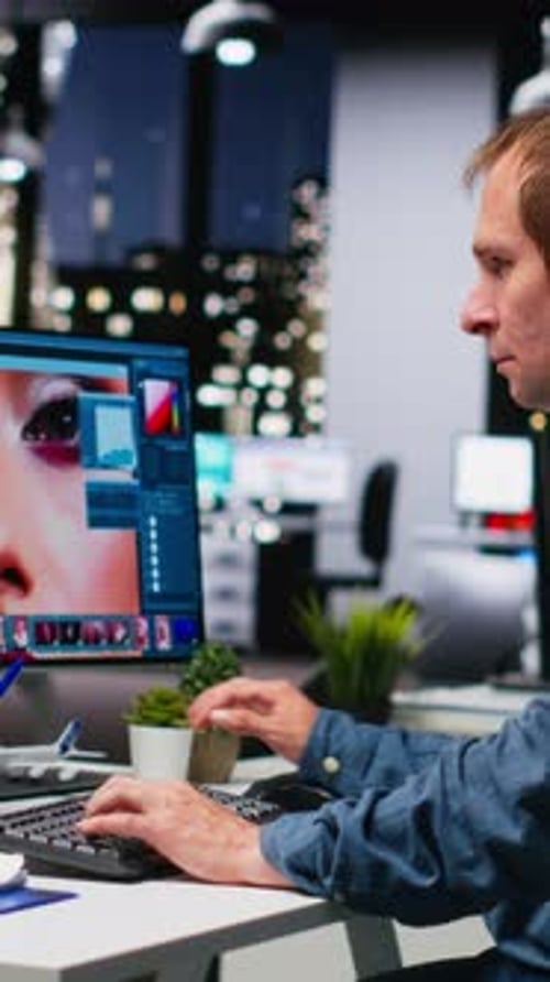Man Typing at Computer in Dark Office at Night