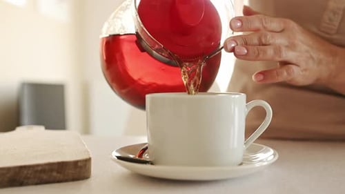 Teezubereitung mit Teekanne und Tassen in der Küche