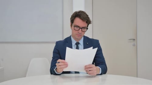 Man Reviews Documents in Bright Office Workplace