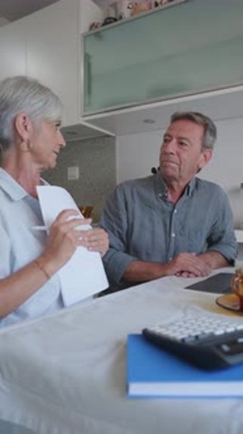 Senior Couple Discussing Finances in Modern Kitchen