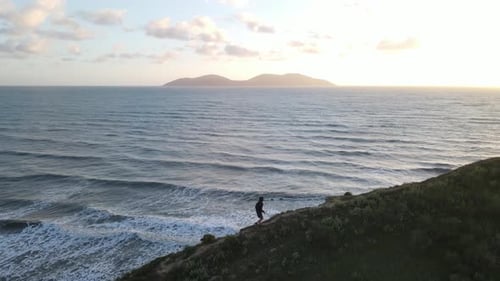 Man running on ridge of mountain, beautiful sunset view of ocean and islands , Vlore , Albania