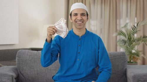 Adult Man Holding Money Indoors Smiling