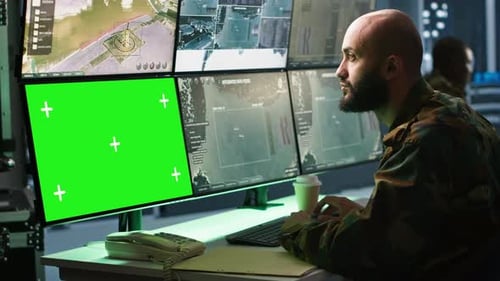 Army Soldier Looking at Chroma Key Screens in Command Center