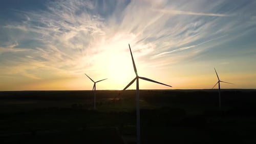 Große Windturbinen mit Rotorblättern im Feld, Luftbild, leuchtend orange, Sonnenuntergang, blauer Himmel, Windpark, Zeitlupe