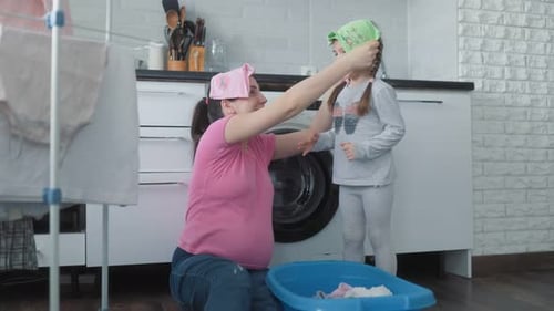 Mother and Daughter Share Fun Moments While Doing Laundry at Home