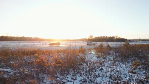 Cars Driving on Snowy Road at Sunrise