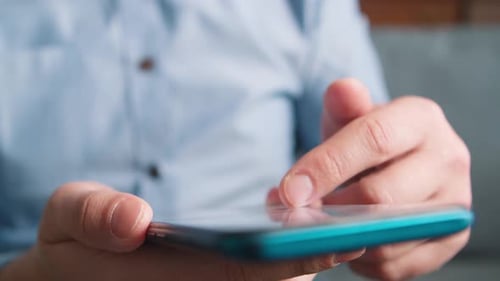 Person's Hands Using Blue Smartphone Device