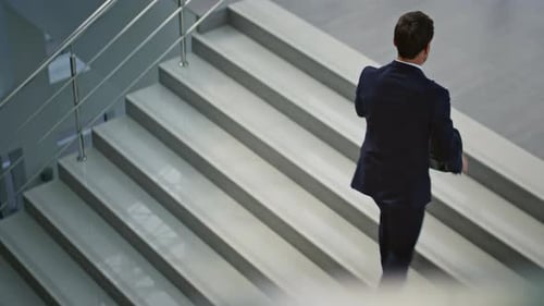 Hurrying Businessman Carrying Briefcase Climbing Stairs Inside Office Interior