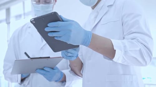 Research Scientists Reviewing Digital Data on Tablet for Lab Analysis and Results