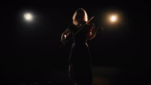 Woman Plays Violin with Dramatic Lighting