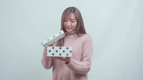 Happy Woman Opening Gift Box Indoors