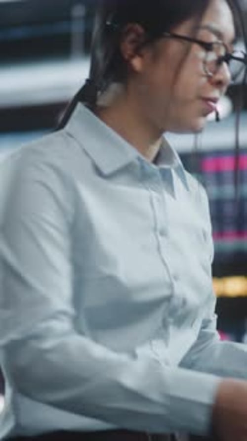 Professional Woman Stands Before Quad Monitor Setup Holding Tablet Monitor Real Time Stock Indices