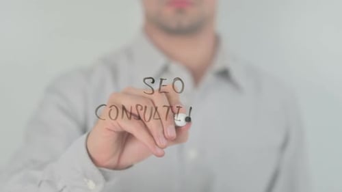 Man Writes SEO Consulting on Clear Screen