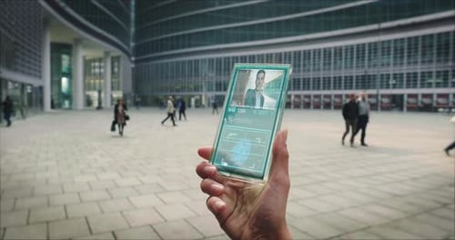 Ralenti de la main d'une femme d'affaires utilisant un téléphone portable en verre futuriste doté des dernières avancées