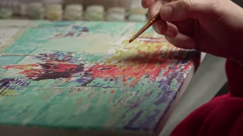 Female with brush drawing. Paint by numbers close up.