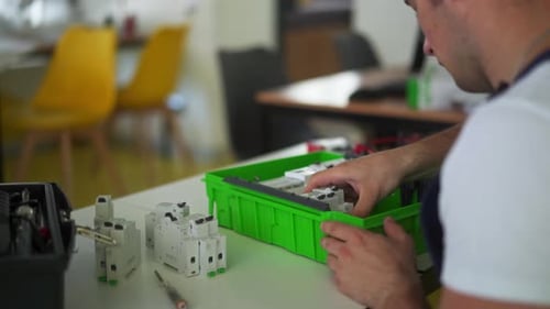Electrician Assembles Electrical Panel Fuse Box in Workshop Worker Installs Energy Meter Switches