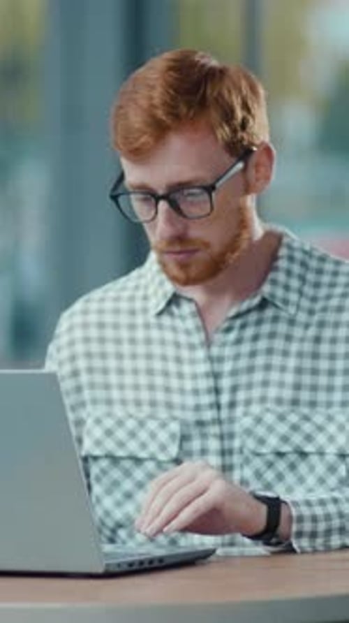 A Bearded Man Works on His Laptop in a Cozy Relaxed Setting