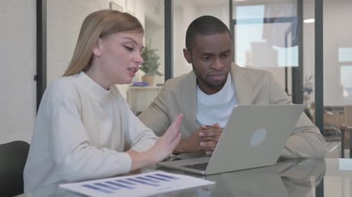 Business Meeting and Reviewing Data on Laptop