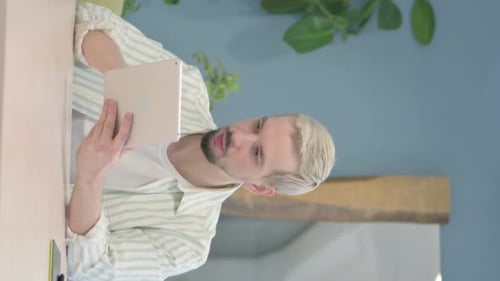 Young Adult Holding Tablet Talking