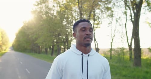 Close Up of Happy Young Handsome Male Athlete Jogging Outdoors Alone on Street African American