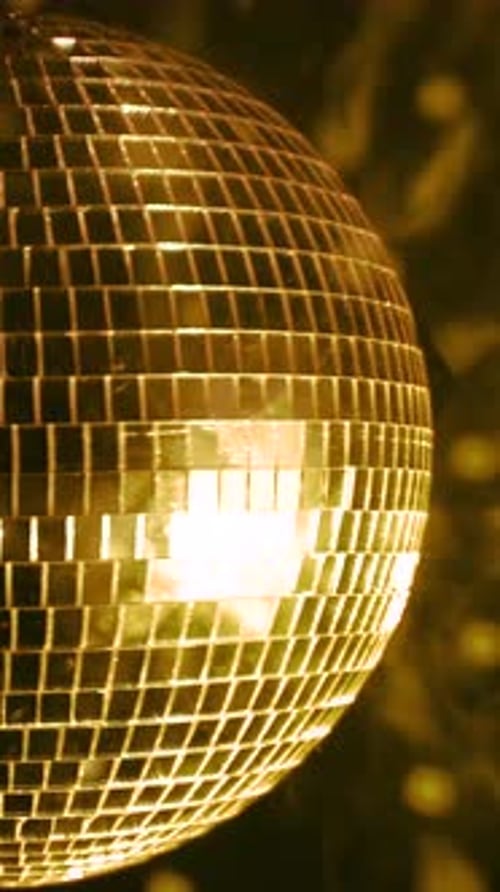 Shimmering disco ball reflecting light. Vertical