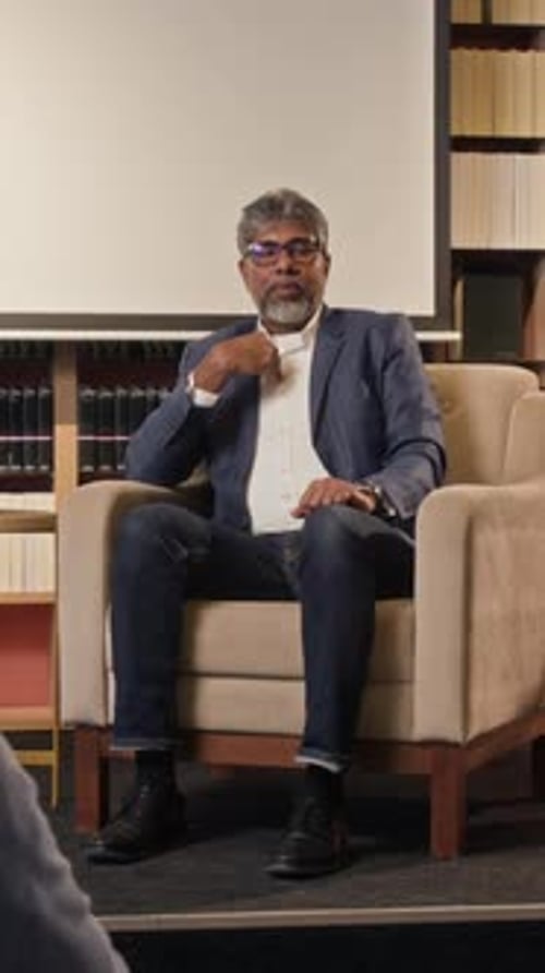 Man Sitting and Talking in an Armchair