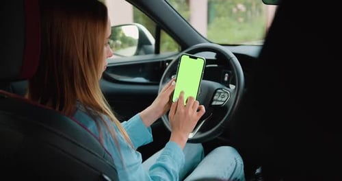 Young blonde woman hands holding smartphone with vertical green screen using mobile application