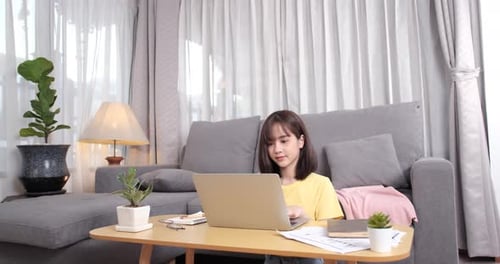 Woman Working on Laptop at Home During Day