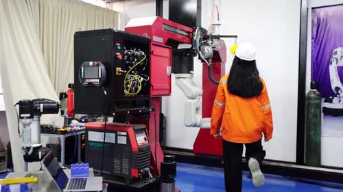 Los ingenieros inspeccionan y revisan la máquina de los robots de soldadura de máquinas de brazos automatizados en la fábrica.