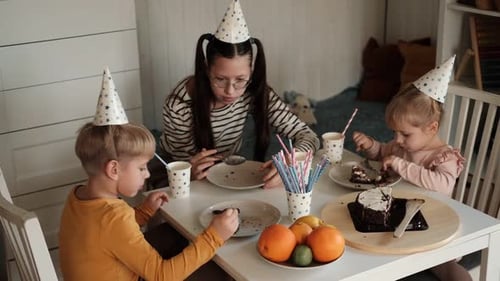 Children Eating Birthday Cake Slice on a Birthday Party at Home Siblings Girls and a Boy Together
