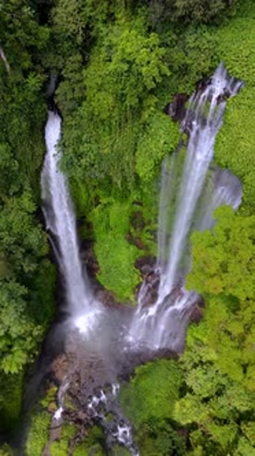Drone View of Cascading Waterfall Surrounded By Tropical Jungle in Bali Indonesia