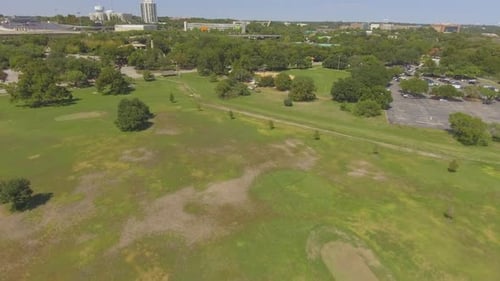 Ein sonniger Nachmittag in einem Stadtpark, der mit schönen Bäumen bedeckt ist. Derselbe Park wird auch zum Spielen verwendet