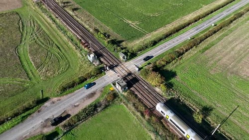 Train de banlieue rapide passant au-dessus d'un passage à niveau