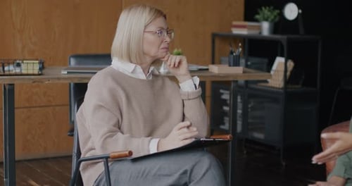 Woman With Clipboard Talking in Office