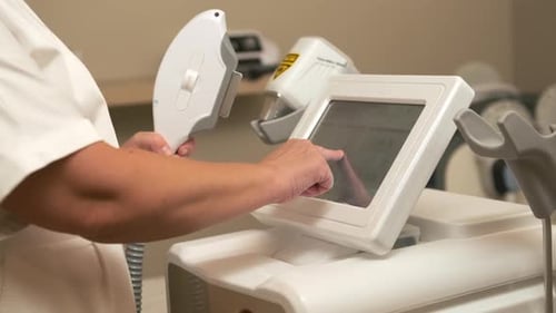 Beautician Tries to Adjust Screen Settings of Hair Removal Set