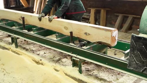 Woodworker Moves a Raw Log on Saw Machine