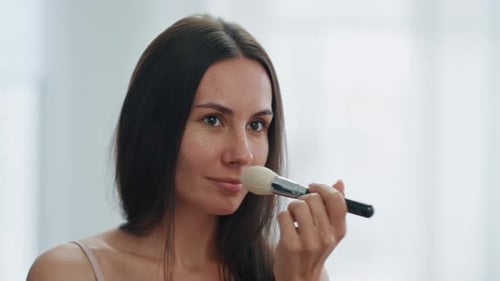 Woman Applying Makeup with Brush Close Up