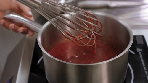 Stirring Red Sauce in a Pot on a Stove