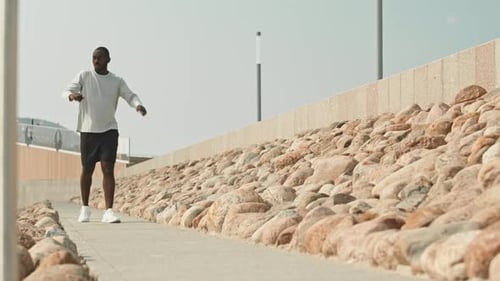 Man Stretching Before Run on Urban Walkway