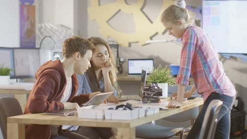 Teens Working Together on Laptop and Robot Project
