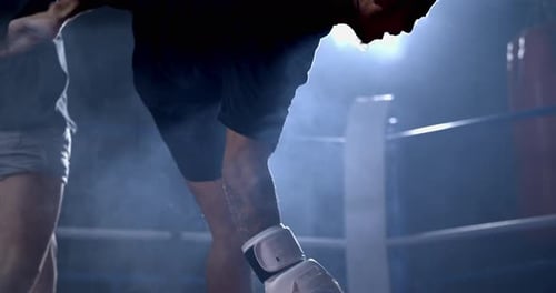 Un homme dans un duel de Muay Thai : Leg Strike envoie un boxeur sur la toile, une descente illuminée de façon spectaculaire capturée à 800