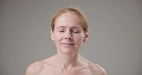 Blonde Woman Smiling Subtly in Studio Close Up