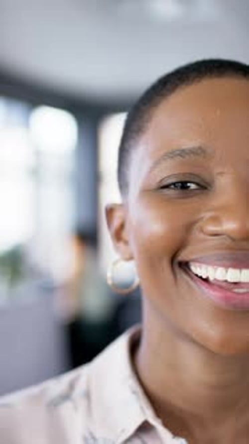 Vertical video of smiling african american businesswoman in office, slow motion, copy space