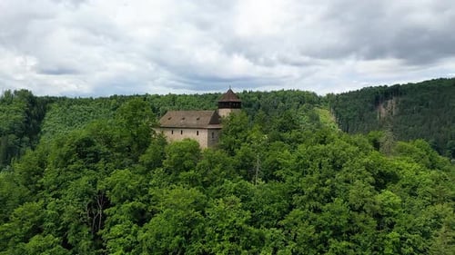 Small Brick Castle on a Hill in Central Europe Surrounded by Trees - Aerial Reveal Shot