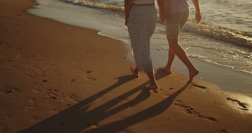 Young Loving Couple Enjoying Relaxing Sunset Walk on the Beach